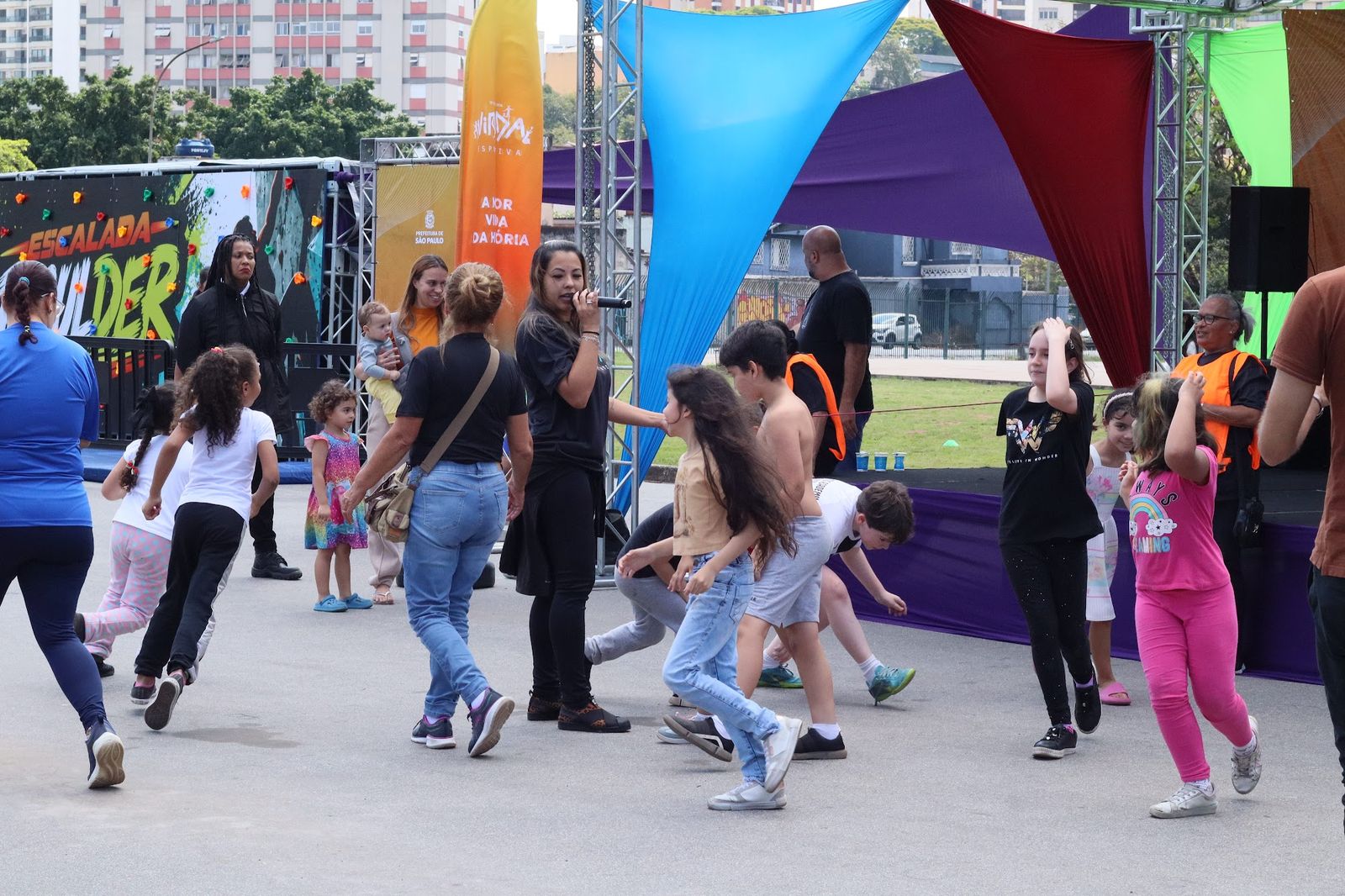 Crianças e adultos dançando juntos na arena